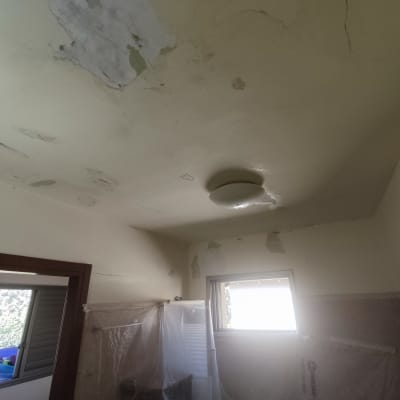 תקרה מתקלפת עם סימני רטיבות ותיקונים