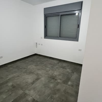 חדר ריק עם רצפה נקייה וחלון סגור