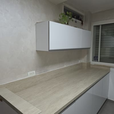 מטבח עם משטח שיש וארונות לבנים
