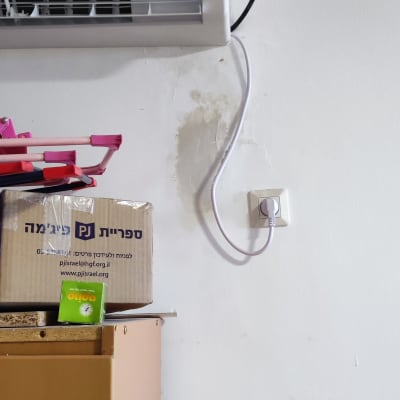 מזגן מותקן על קיר עם כבל חשמל מחובר