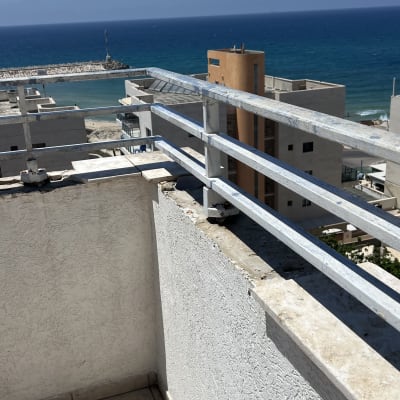 מרפסת עם נוף לים ומעקה מתכת