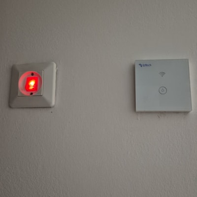 מתג חשמלי ומכשיר IoTech על קיר