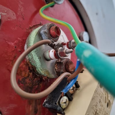 חוטי חשמל מחוברים למכשיר עם ברגים