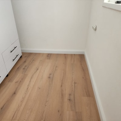 רצפת פרקט עץ בהירה ליד ארון לבן