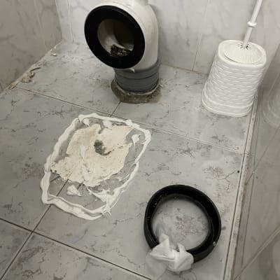 צינור ביוב וחלקים על רצפת חדר אמבטיה