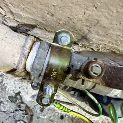 חיבור כבל חשמל צהוב ירוק לצינור מתכת