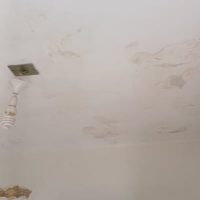 תקרה מתקלפת עם סימני רטיבות וכתמים