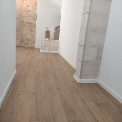 רצפת פרקט עץ בחדר עם קירות לבנים