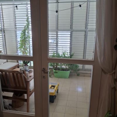 דלת זכוכית עם נוף למרפסת וצמחים