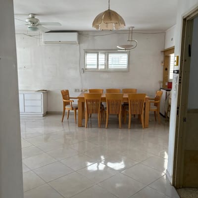 חדר אוכל עם שולחן וכיסאות מעץ, מאוורר תקרה ומזגן