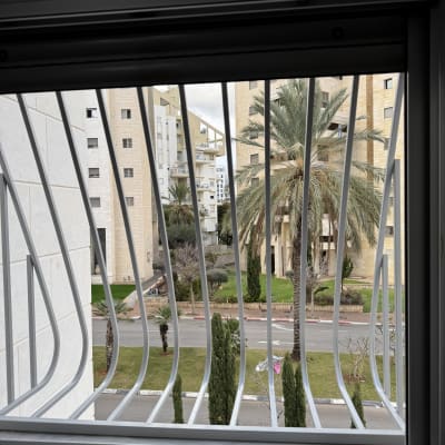 סורגי מתכת על חלון עם נוף חיצוני