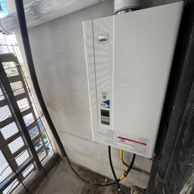 מחמם מים גז מותקן על קיר עם צינורות