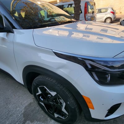 רכב לבן עם פגמים קלים בפגוש הקדמי