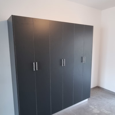 ארון שחור עם דלתות ומגירות בחדר ריק