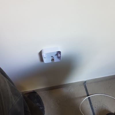 בסיס שקע חשמלי מותקן על קיר לבן