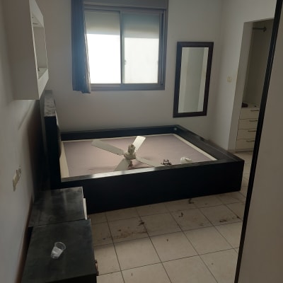 חדר עם לכלוך על הרצפה וכוס פלסטיק על השידה