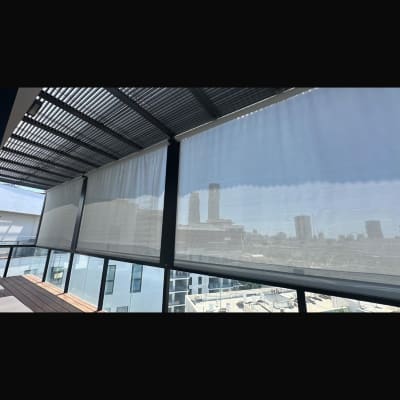 פרגולה עם וילונות נוף עירוני ברקע