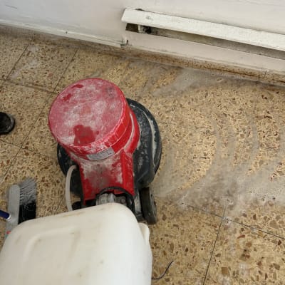 מכונת ניקוי אדומה על רצפת טרצו מלוכלכת