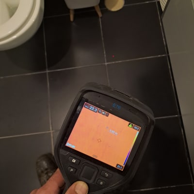 מד חום אינפרא אדום בשירותים עם רצפת אריחים שחורה