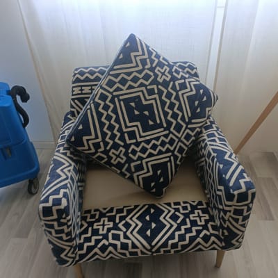 מכונת ניקוי ספות ליד כורסה עם כרית מעוצבת