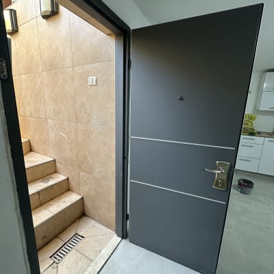 דלת אפורה פתוחה עם ידית מתכת כסופה