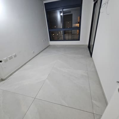 חדר ריק עם רצפה נקייה וחלון גדול