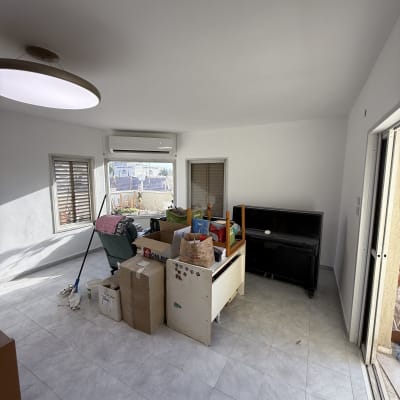 חדר עם קירות צבועים, ארגזים וכלי ניקוי