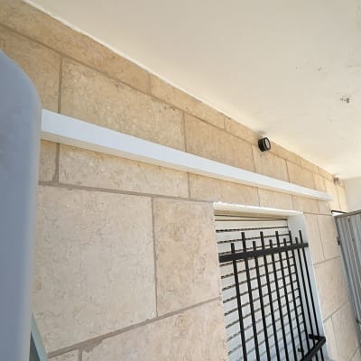 צינור מיזוג אוויר על קיר חיצוני עם סורג חלון