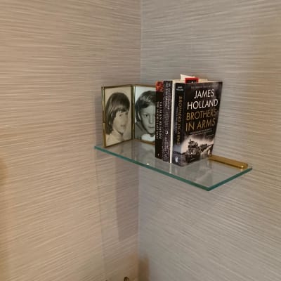 מדף זכוכית עם ספרים ותמונות במסגרת זכוכית