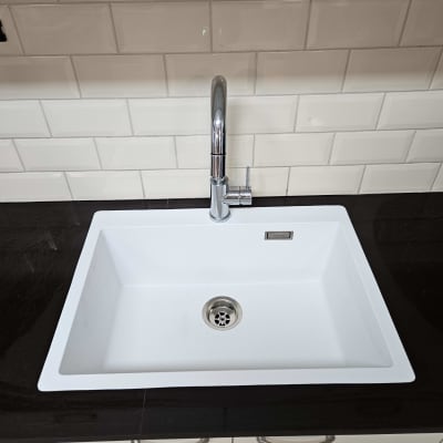 כיור לבן עם משטח שיש כהה וברז כרום