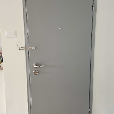 דלת אפורה עם ידית מתכת ובריח עליון