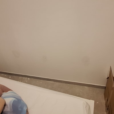 חדר עם מיטה, קיר וארגז קרטון בפינה