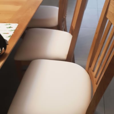 ריפוד לבן על כיסאות עץ ליד שולחן