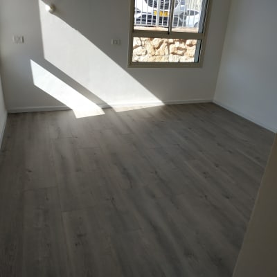 רצפת פרקט עץ כהה בחדר מואר