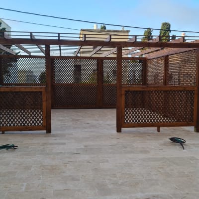 פרגולה מעץ עם רשתות דקורטיביות בחצר