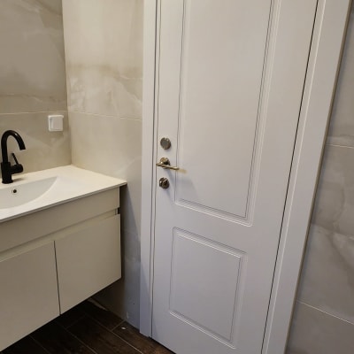 דלת לבנה עם ידית מתכת בחדר אמבטיה