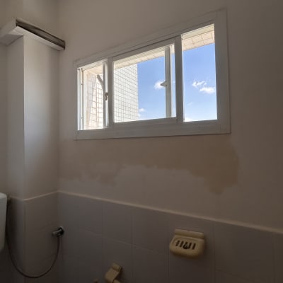קיר עם חלון ותיקוני צבע בחדר אמבטיה