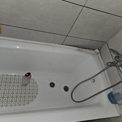 אמבטיה עם ראש מקלחת וצינור, בקבוק סבון