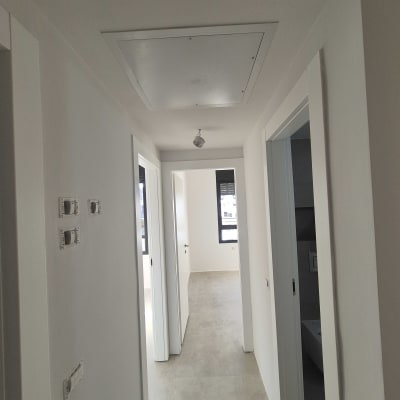 מסדרון עם קירות צבועים ודלתות לבנות