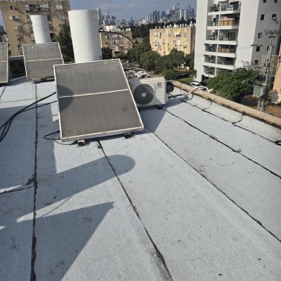 גג עם קולטי שמש ומזגן בבניין מגורים
