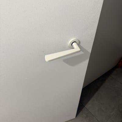 ידית דלת לבנה על דלת לבנה