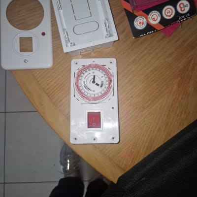 טיימר חשמלי ומכסה שקעים על שולחן עץ