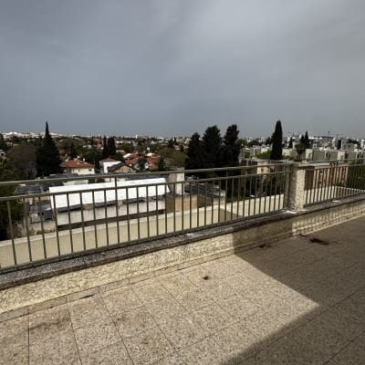 מרפסת עם מעקה ונוף עירוני ברקע