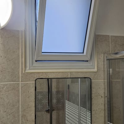 חלון אלומיניום פתוח בחדר אמבטיה עם מראה