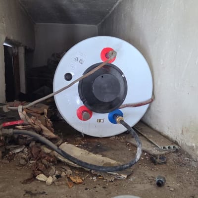 דוד שמש מותקן בחדר קטן עם צינורות מחוברים