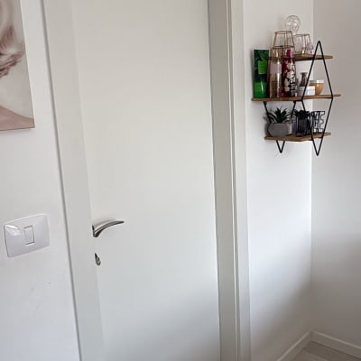 דלת לבנה עם ידית כסופה על קיר לבן