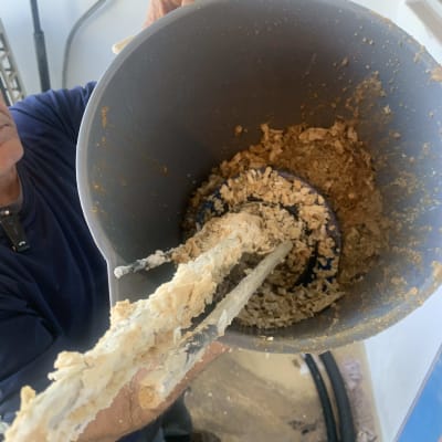 אדם מחזיק דלי עם משקעי אבנית מדוד שמש