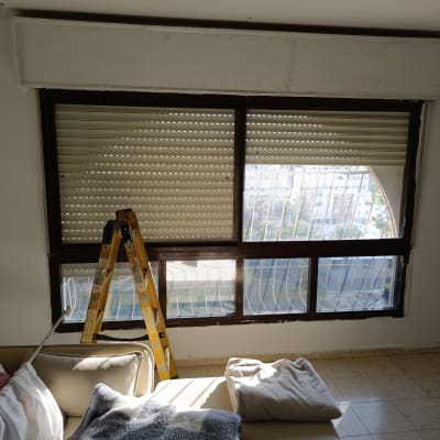 סולם ליד חלון עם תריסים סגורים