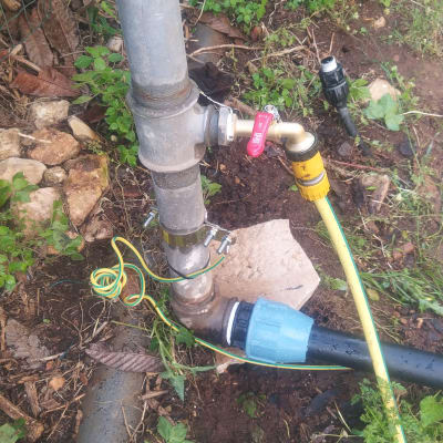 צינור מתכת עם ברז אדום וצינור פלסטיק צהוב