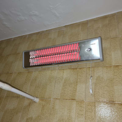 תנור חימום חשמלי מותקן על קיר בחדר אמבטיה